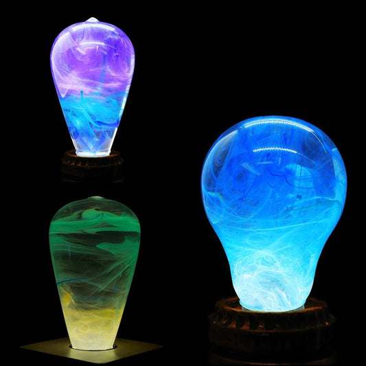 Three colorful light bulb-shaped lamps on a black background