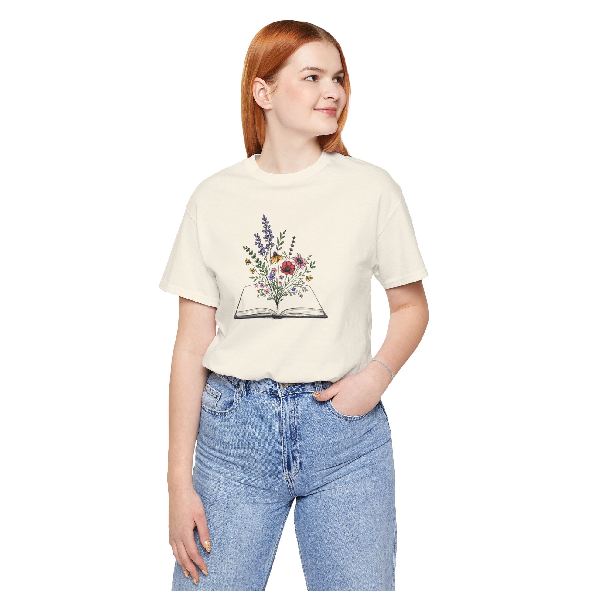 Person wearing a cream t-shirt with a floral book design on a white background
