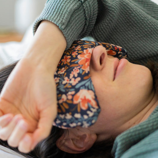 Person wearing a floral eye mask with a blurred background