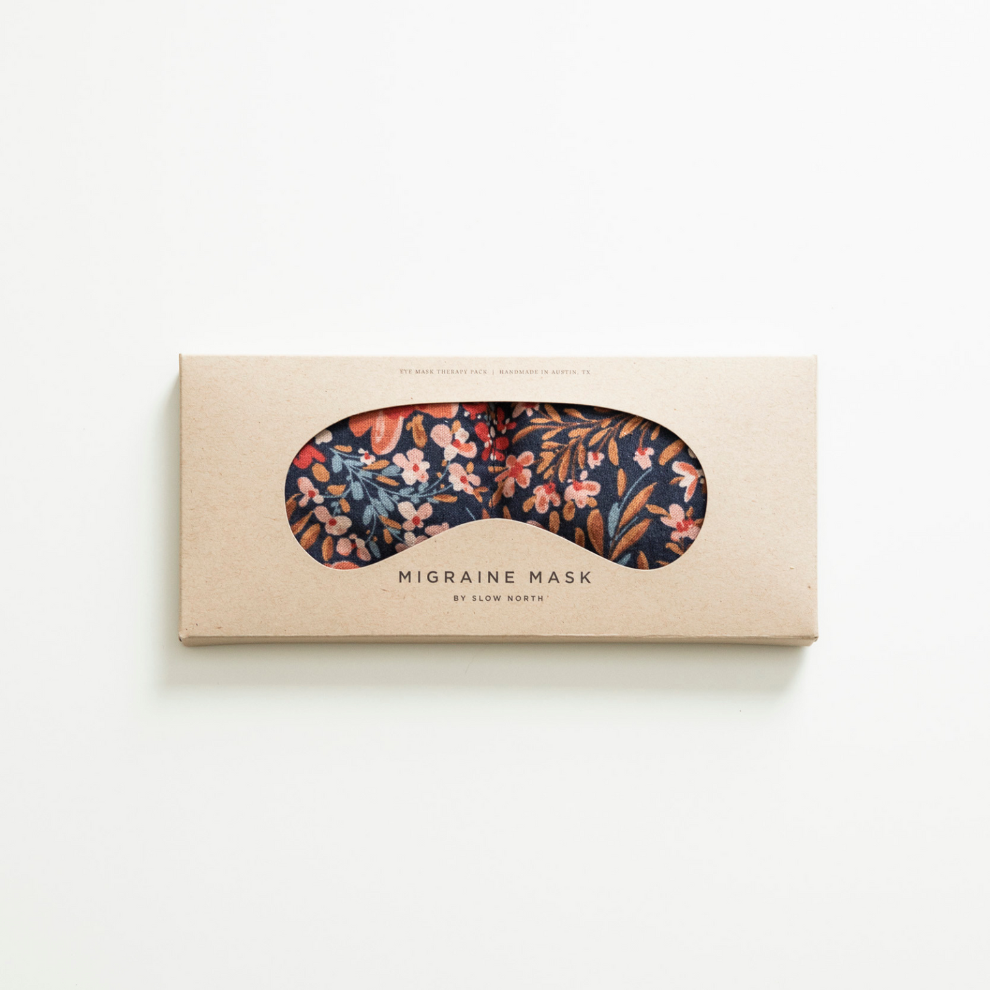 Floral migraine mask in a cardboard box on a white background