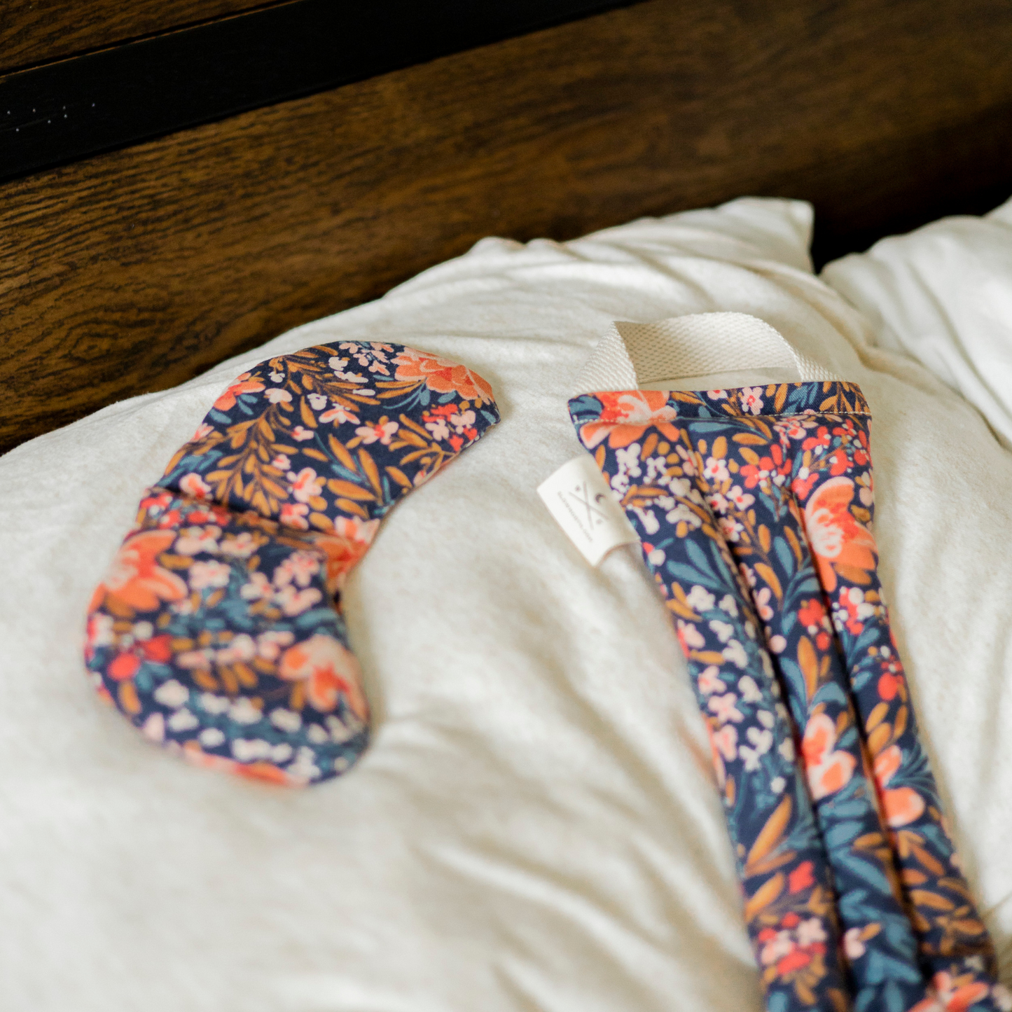 Floral-patterned leggings on a white pillow with a wooden background