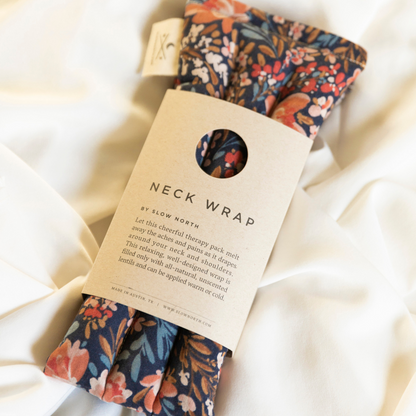 Neck wrap with floral pattern and packaging on a soft fabric background