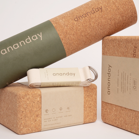 Cork yoga products including a mat, block, strap, and keychain on a light background