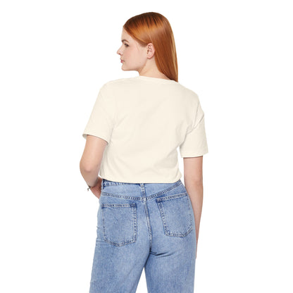 Person wearing a beige t-shirt and blue jeans on a white background