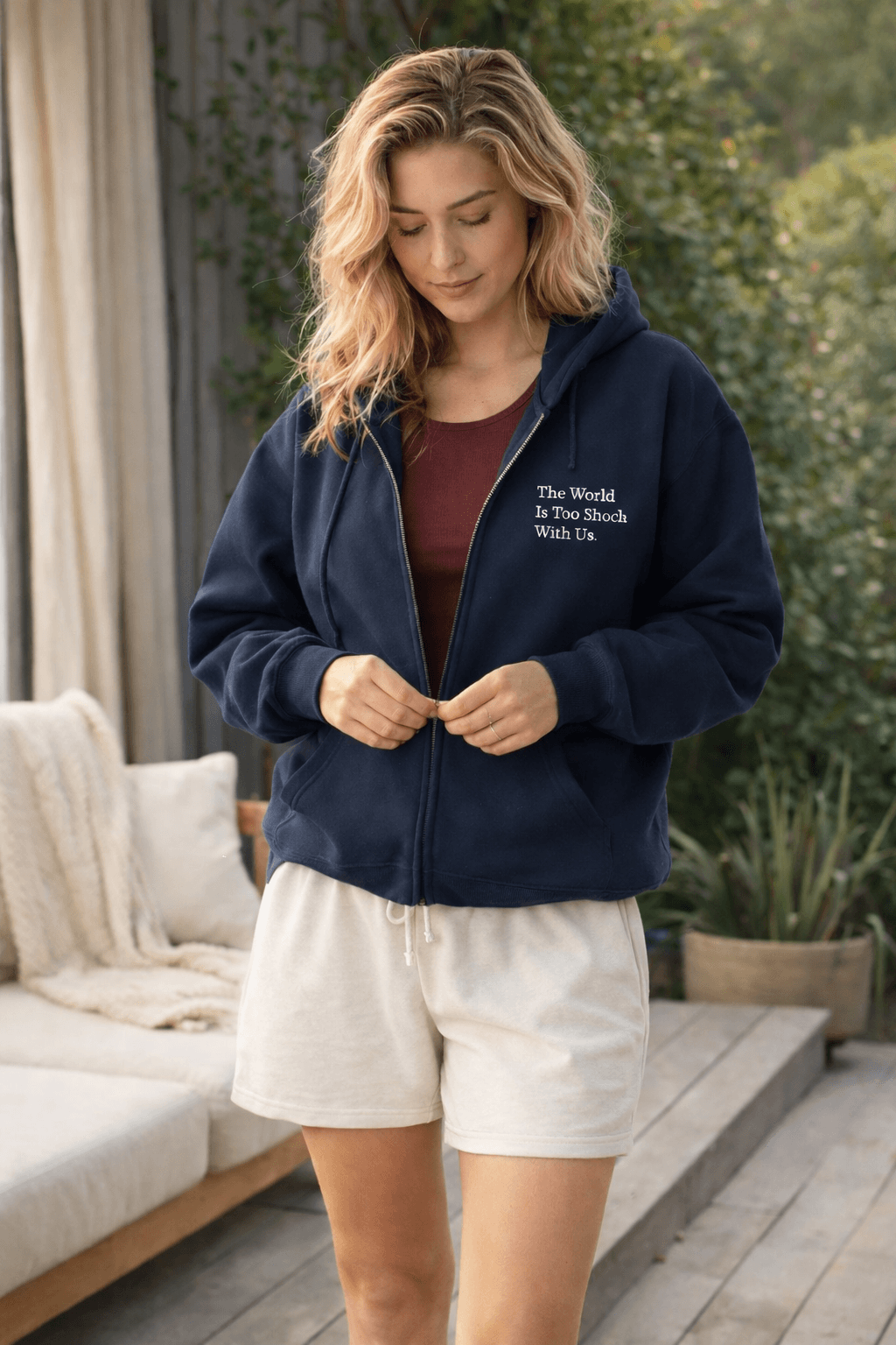 Woman wearing a navy blue hoodie with wordsworth quote outdoors