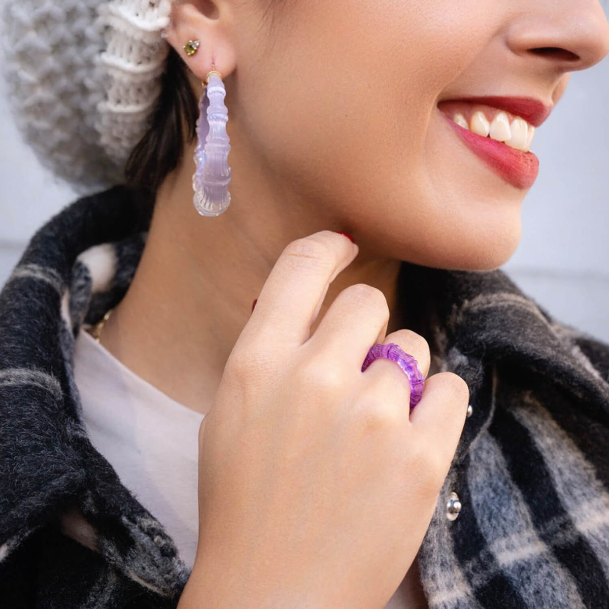 Smiling woman in a plaid scarf wearing lavender bamboo Lucite earrings