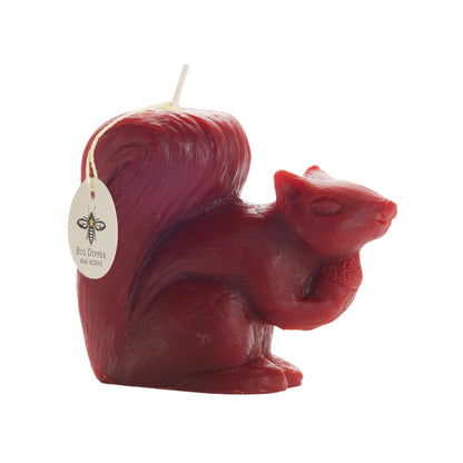 Side view of the red beeswax squirrel candle with Big Dipper Wax Works tag