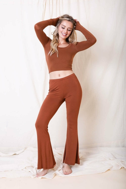 Woman wearing a brown outfit posing against a white background