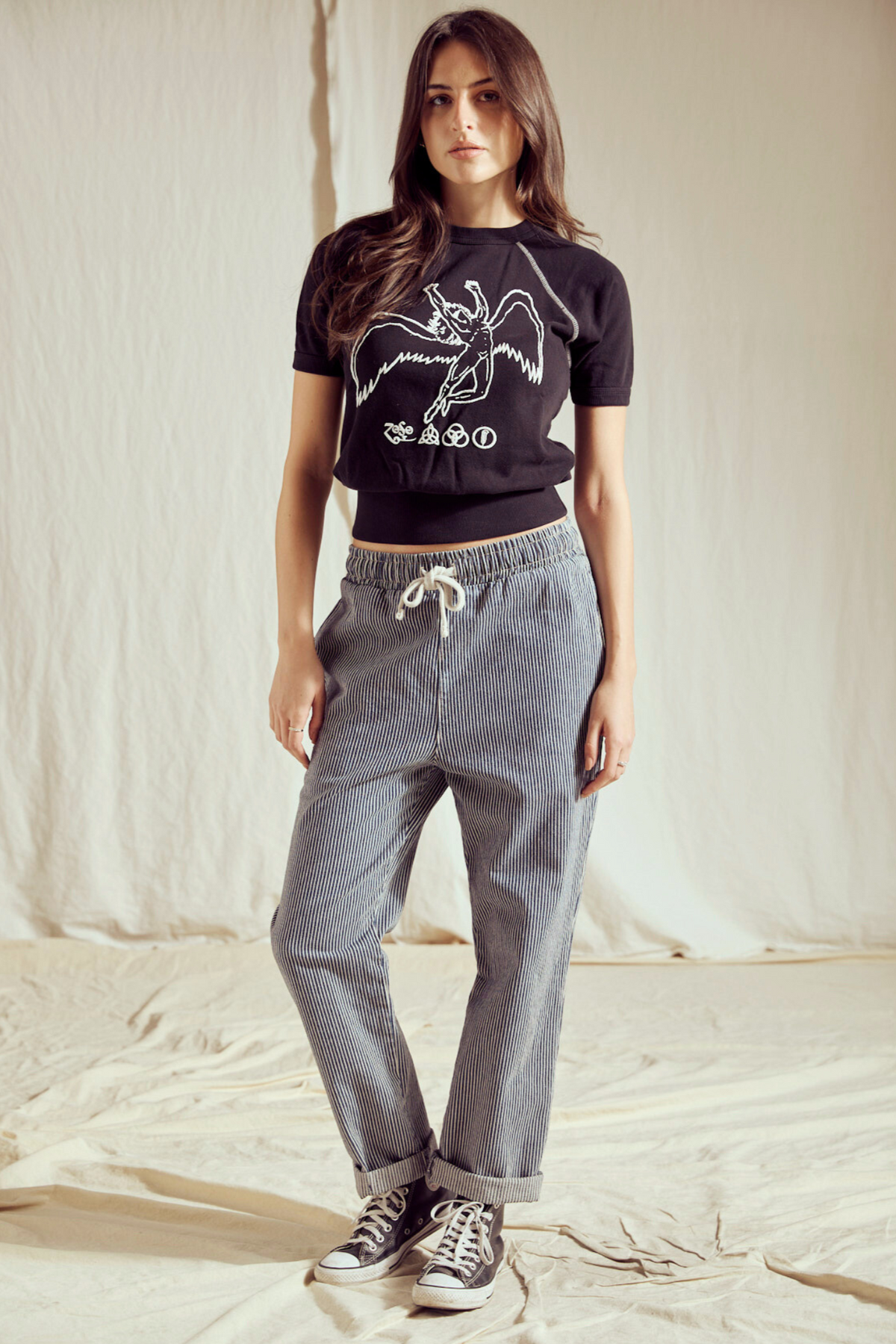 Woman in the Led Zeppelin Icarus raglan tee styled with drawstring jeans and black sneakers