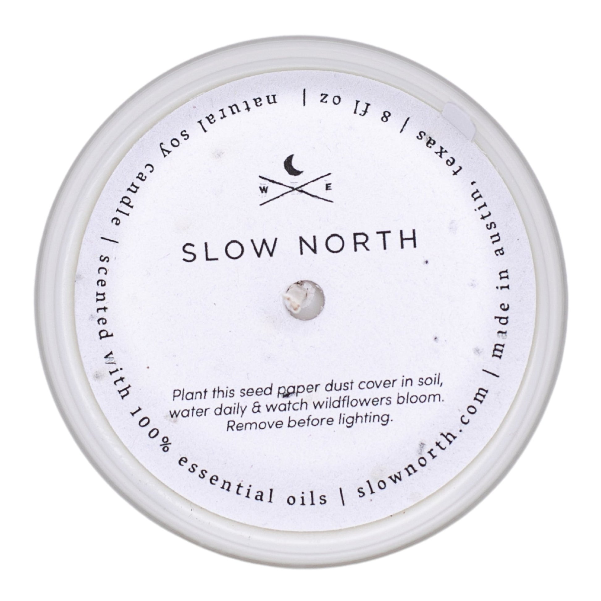 Candle with 'Slow North' branding and label on a white background