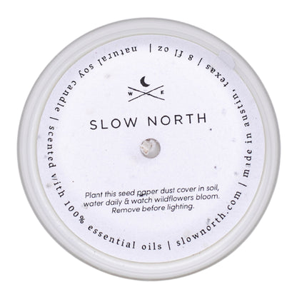 Candle with 'Slow North' branding and label on a white background