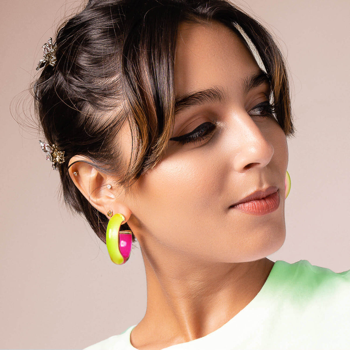 Woman wearing a lime and pink Lucite hoop earring