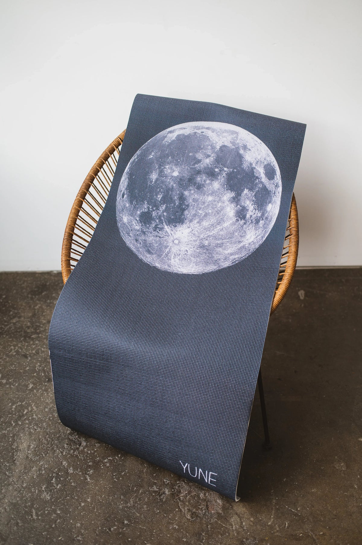 Chair with a cover featuring a moon design on a concrete floor.