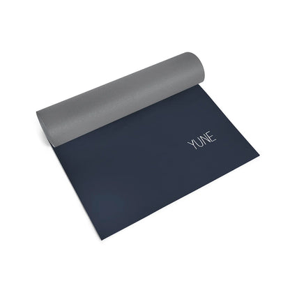 Yoga mat with gray top and dark blue bottom on a white background